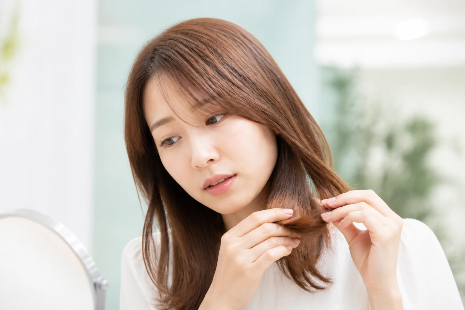 カラー後の毛先を確認する女性